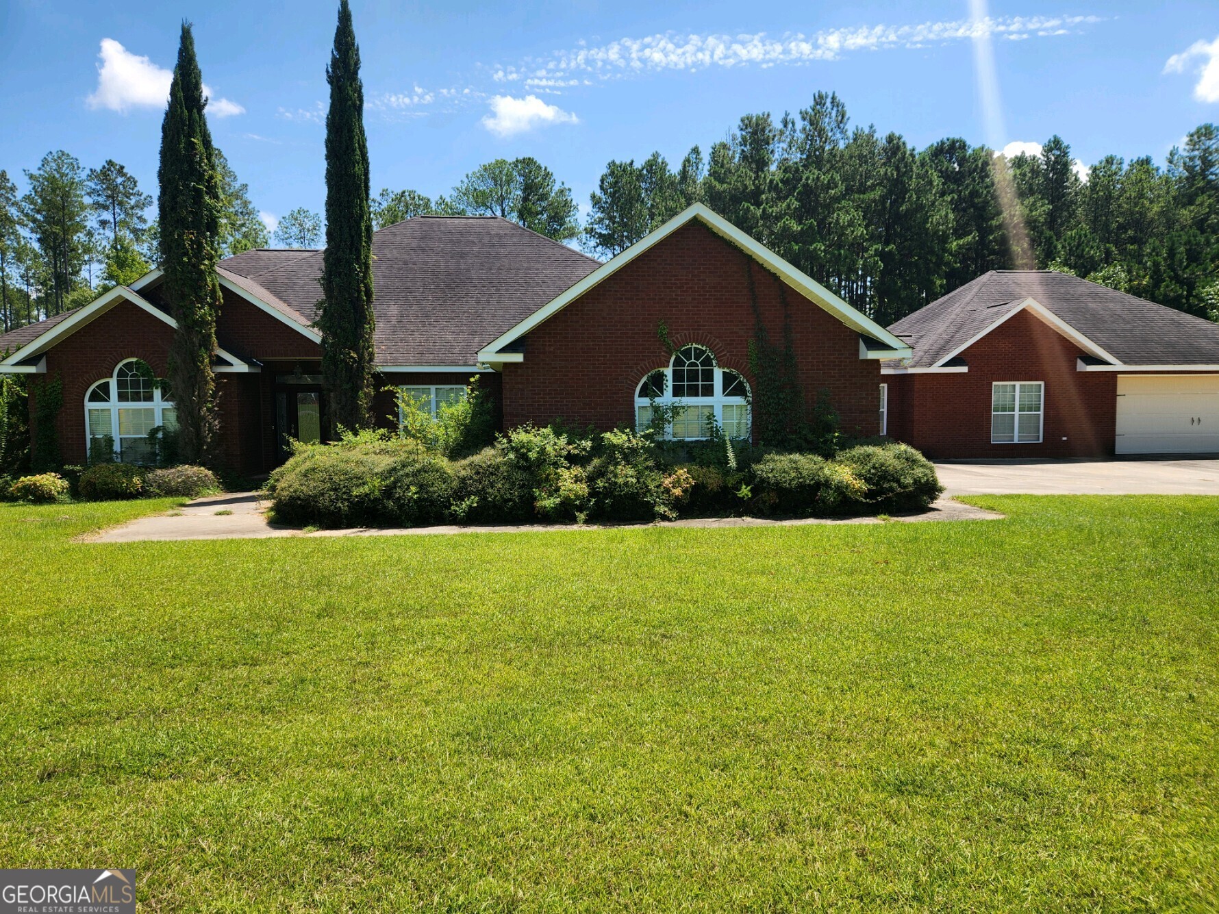 a front view of a house with a yard and trees