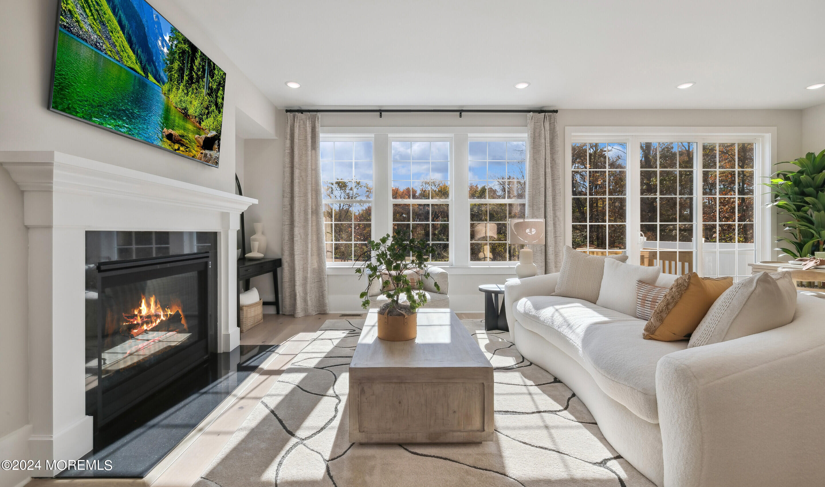 a living room with furniture a fireplace and a floor to ceiling window