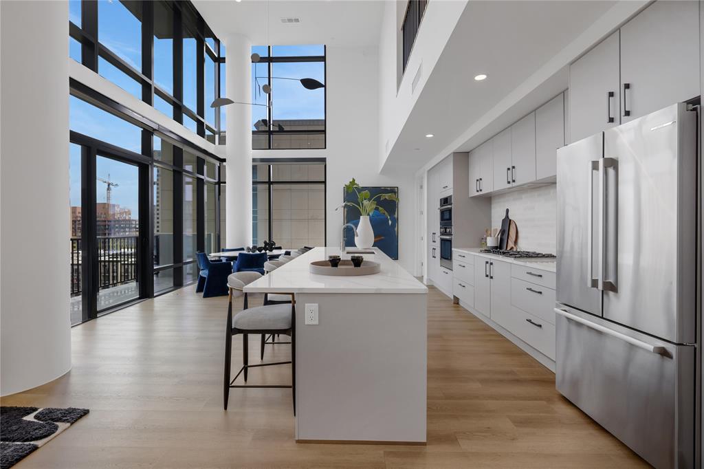 a kitchen with stainless steel appliances kitchen island granite countertop a stove and a refrigerator