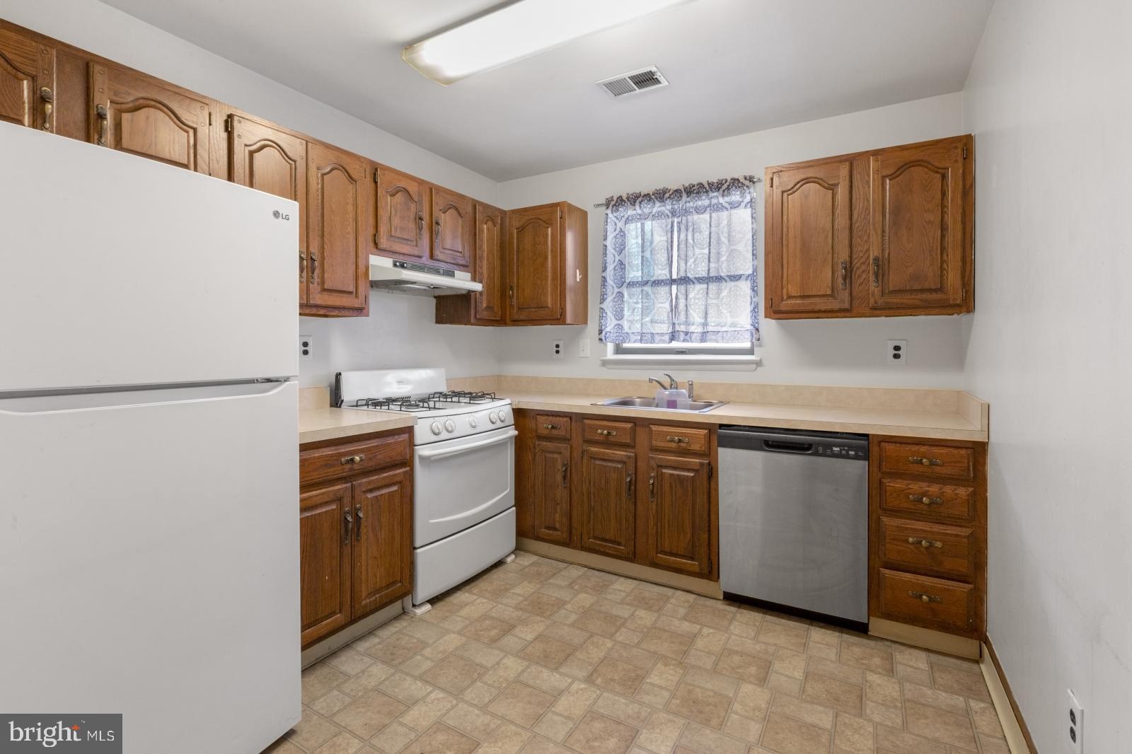 a kitchen with stainless steel appliances granite countertop a refrigerator sink and stove