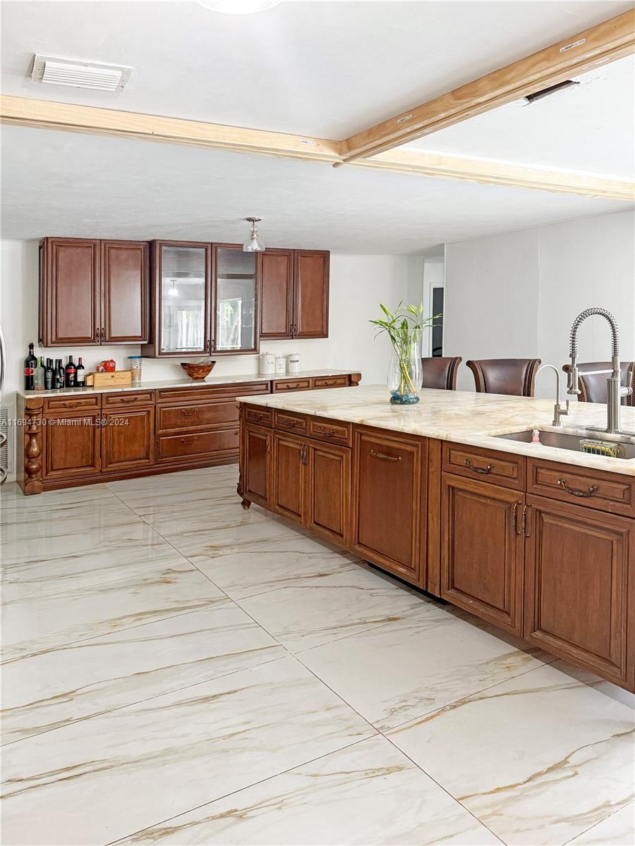 a large kitchen with stainless steel appliances kitchen island granite countertop a sink counter space and cabinets