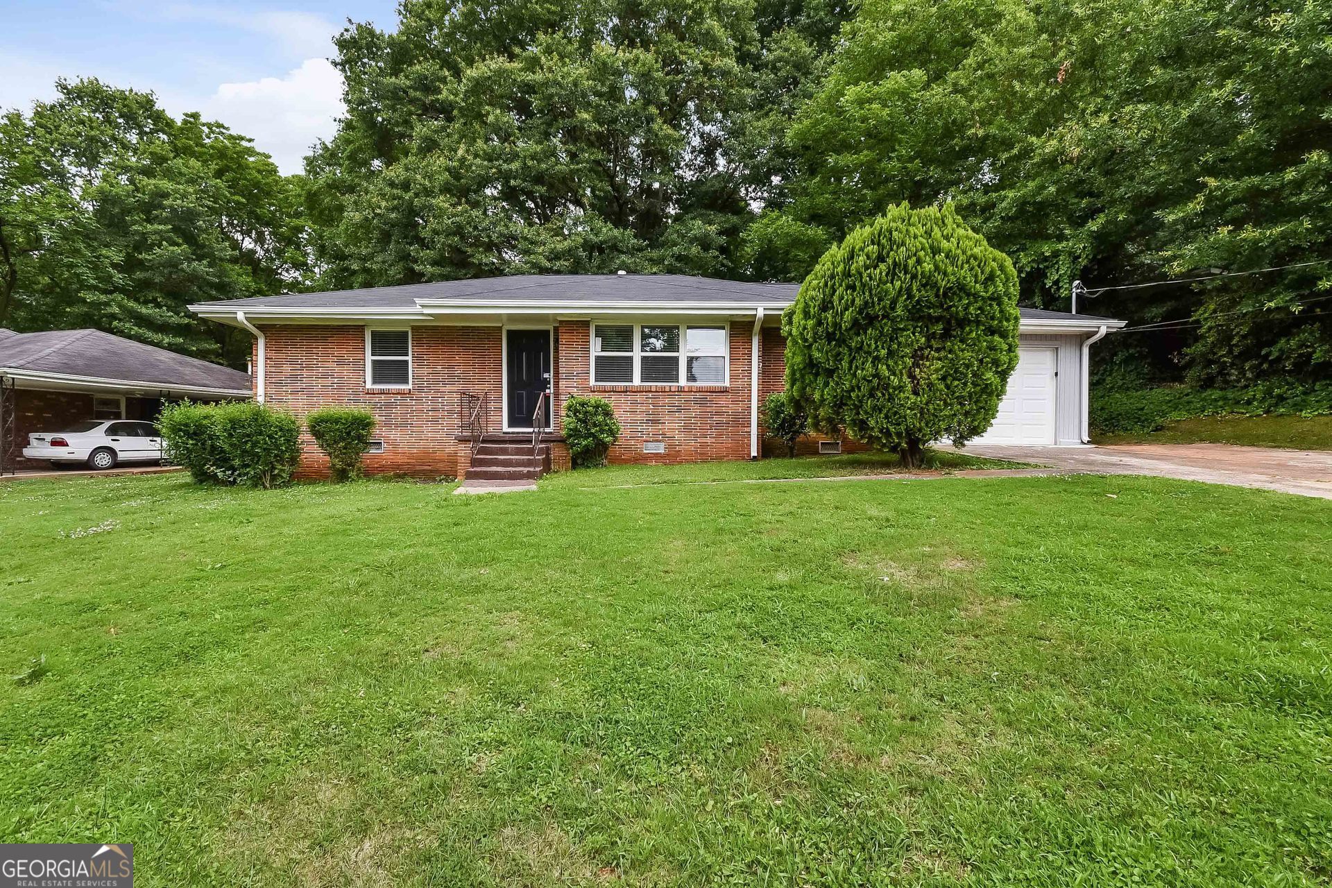 a front view of a house with a yard and trees