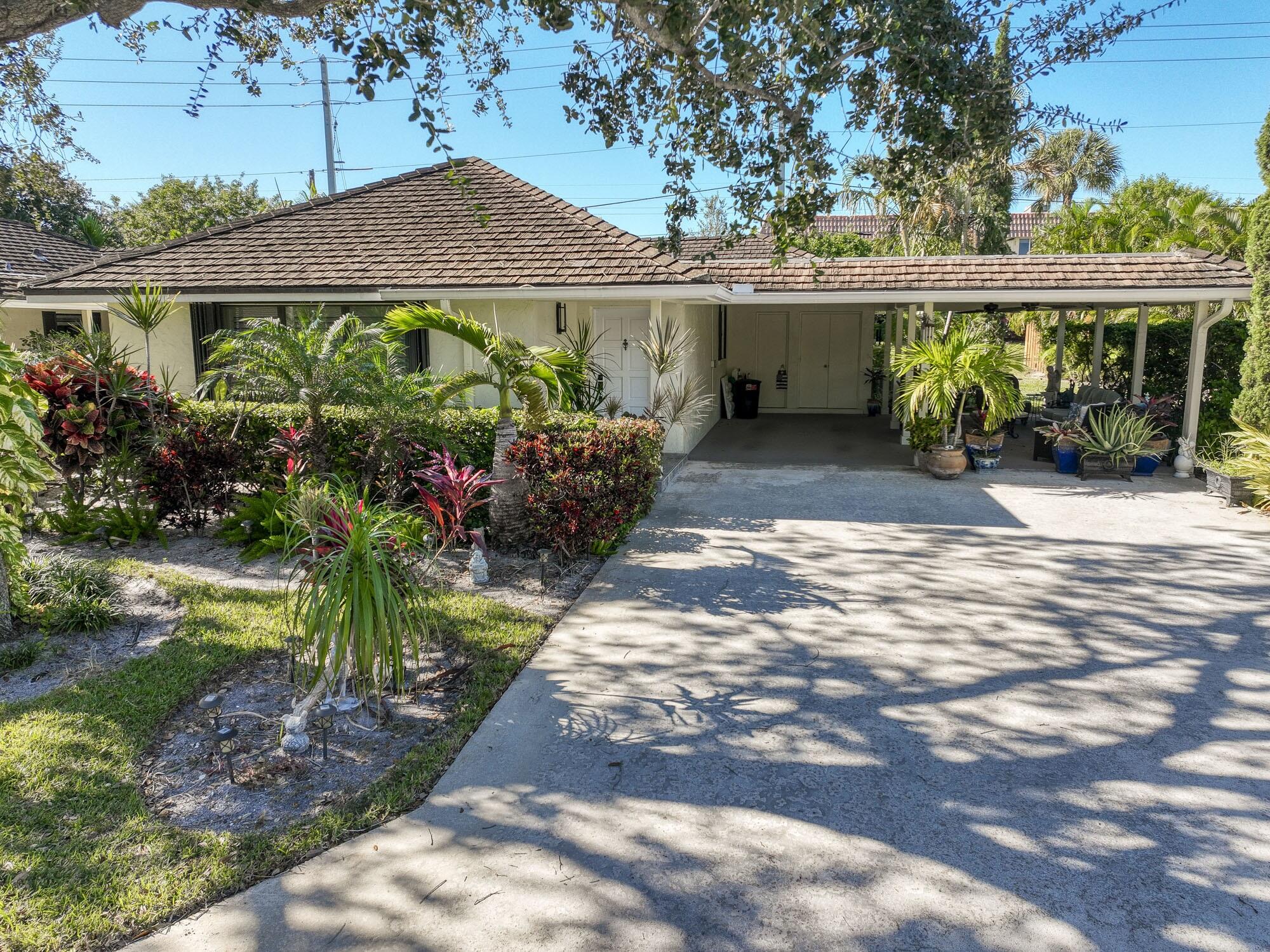 a view of a house with a yard and potted plants