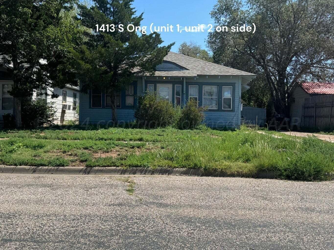 a front view of a house with a yard and trees