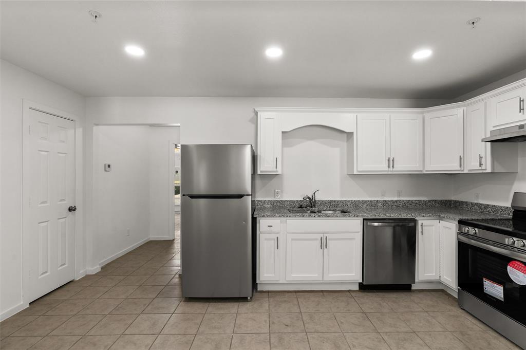 a kitchen with a sink a refrigerator and cabinets