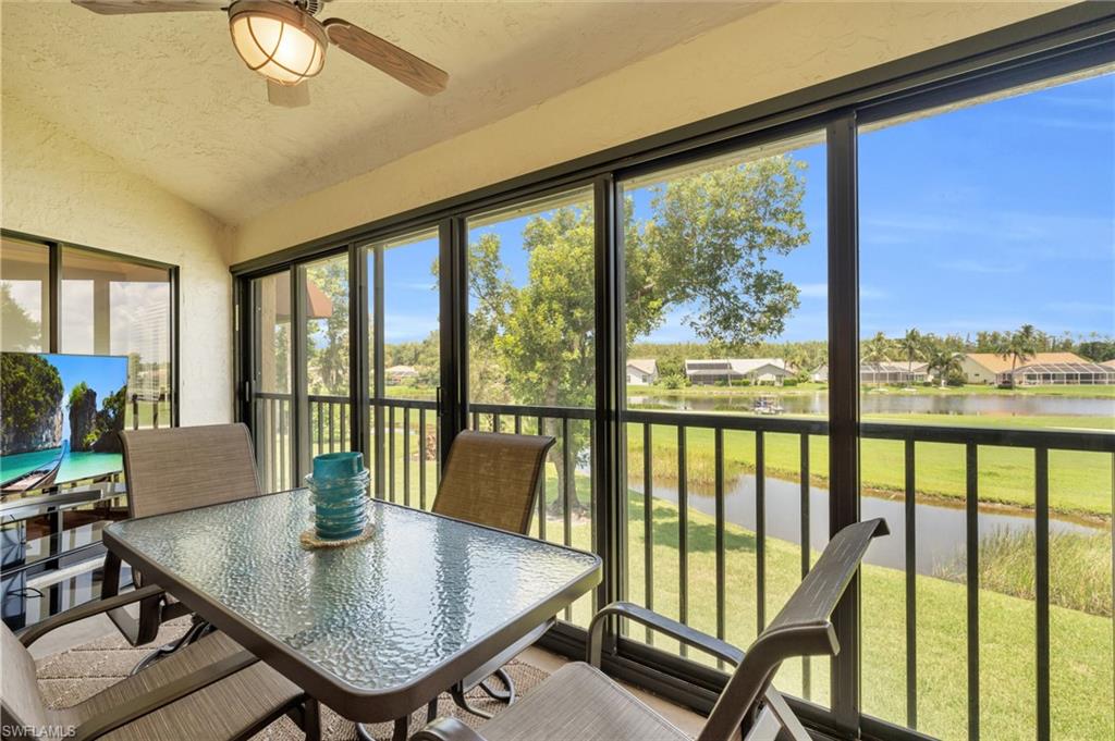 Sunroom with ceiling fan, vaulted ceiling, and a water view