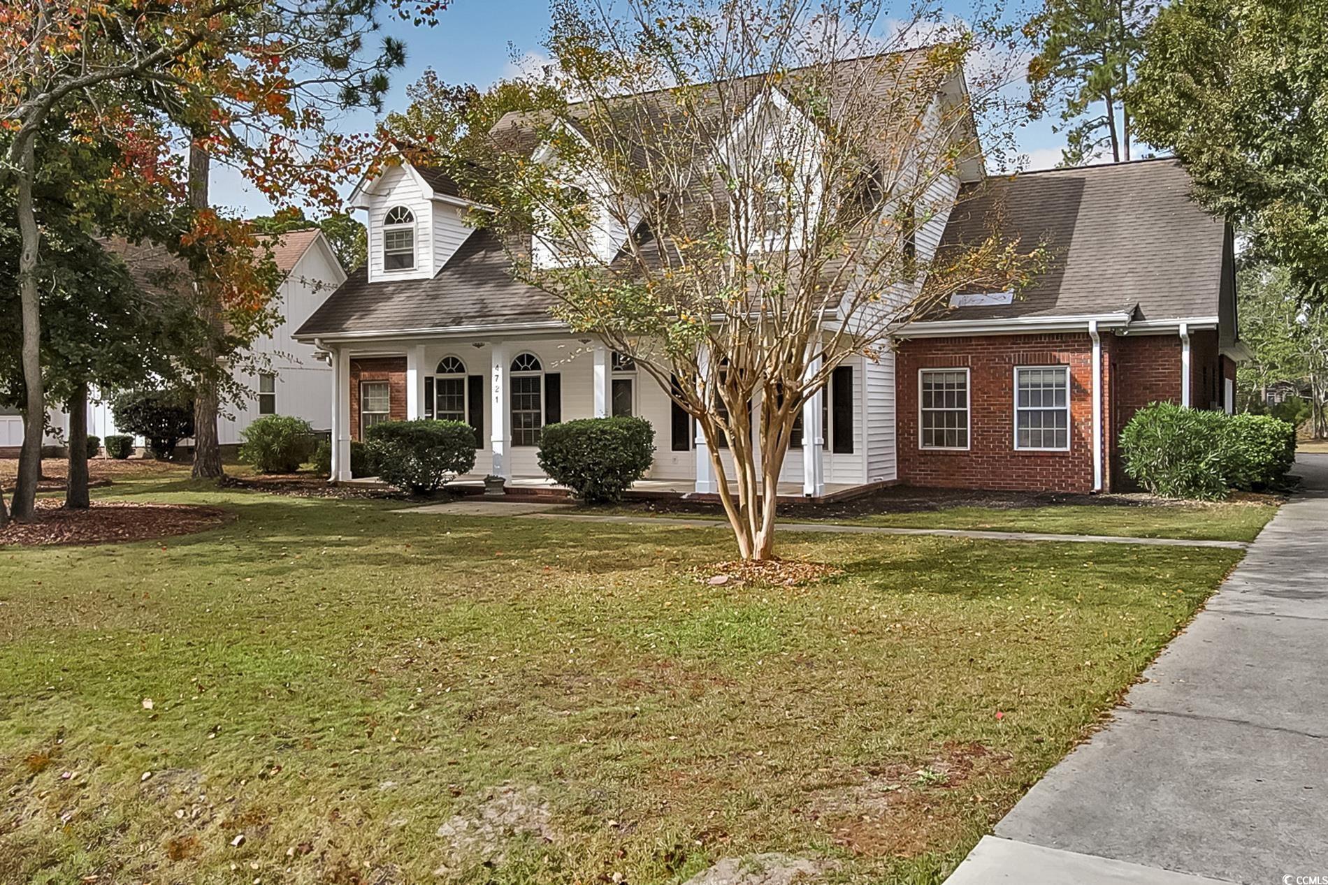 Cape cod-style house with a front lawn and covered