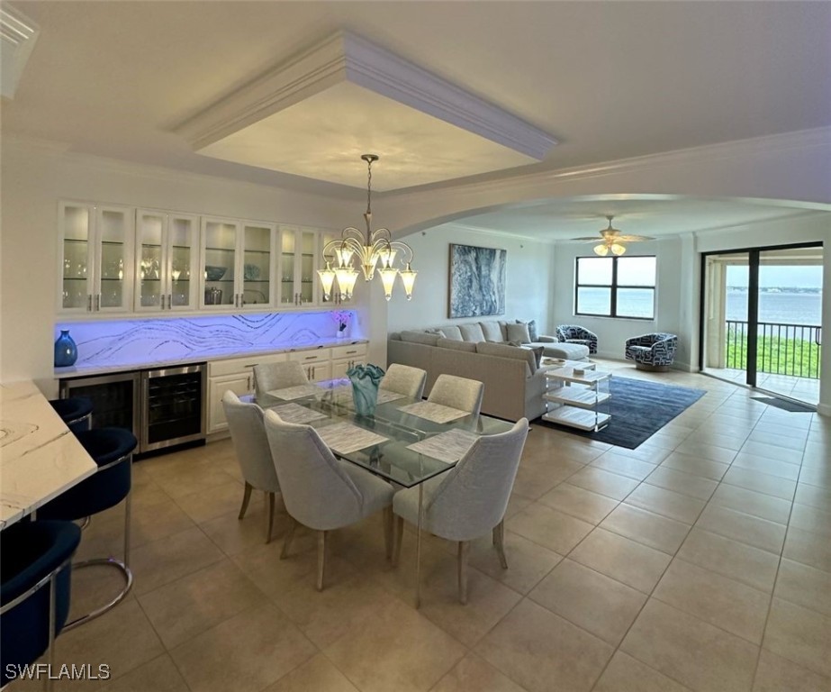 a living room with stainless steel appliances kitchen island granite countertop furniture and a chandelier