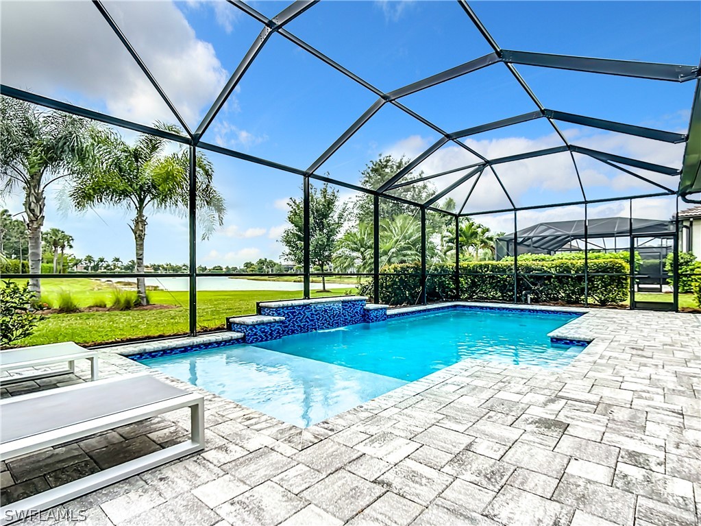 a view of swimming pool with lawn chairs and a yard