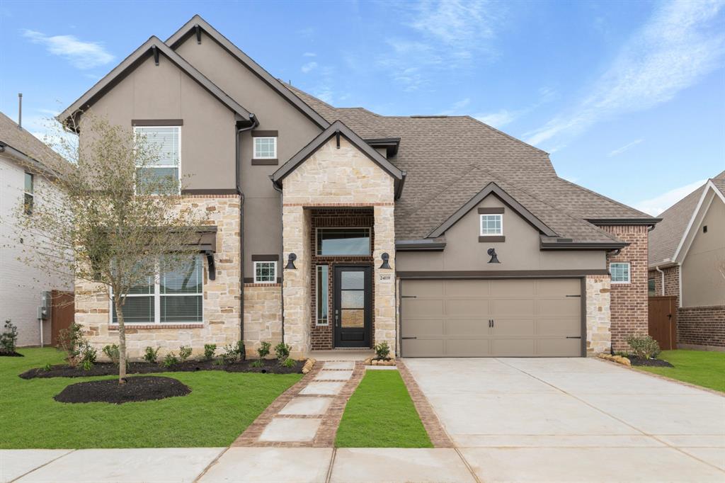 a front view of a house with a yard and garage