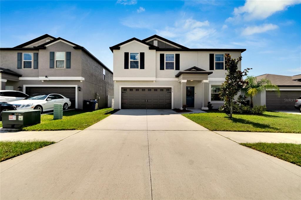 a front view of a house with a yard and garage