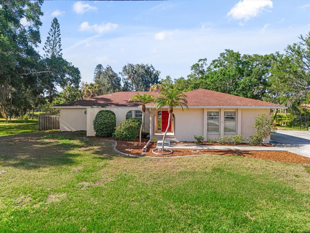 a front view of house with yard and trees in the background