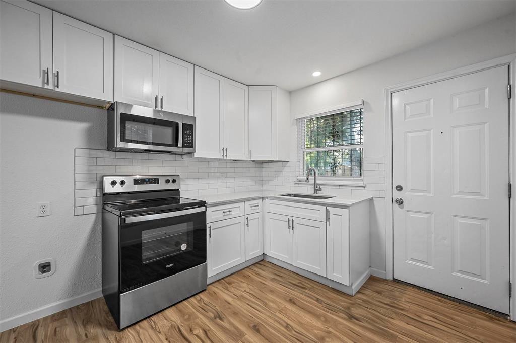 a kitchen with granite countertop cabinets stainless steel appliances and a sink