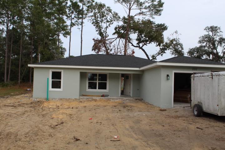 a view of a house with a yard and tree