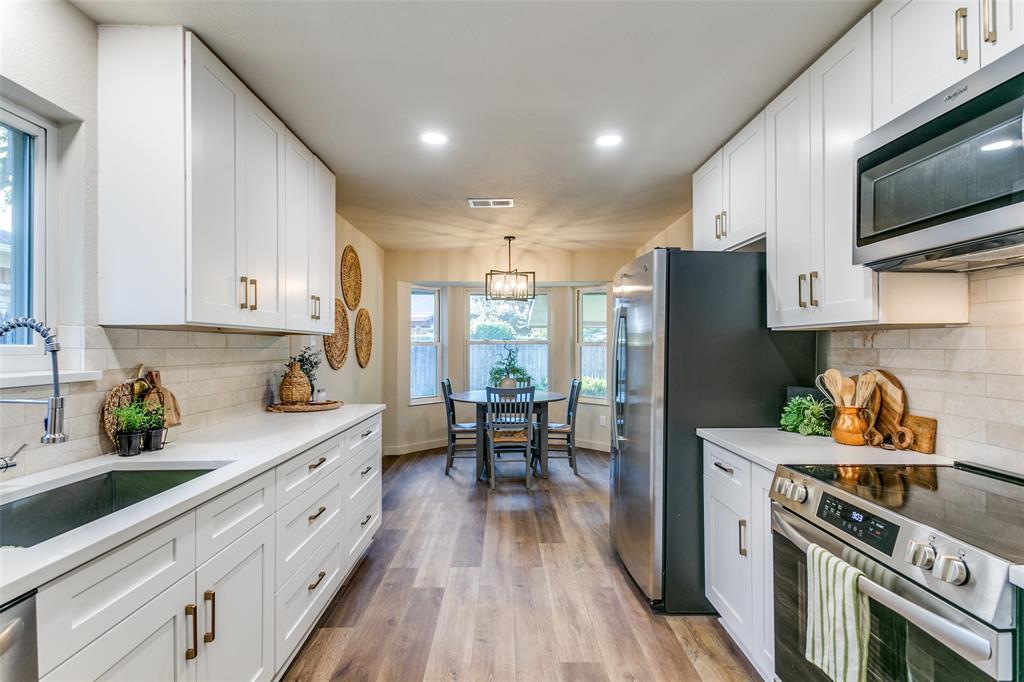 a kitchen with stainless steel appliances a refrigerator a sink a stove and cabinets