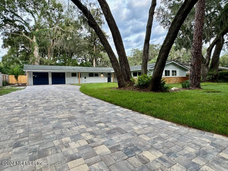 a view of house with backyard and a garden