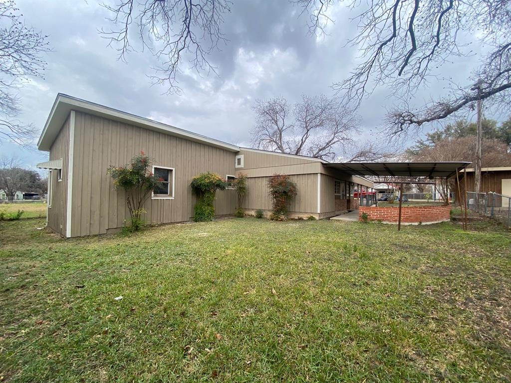 a backyard of a house with table and chairs