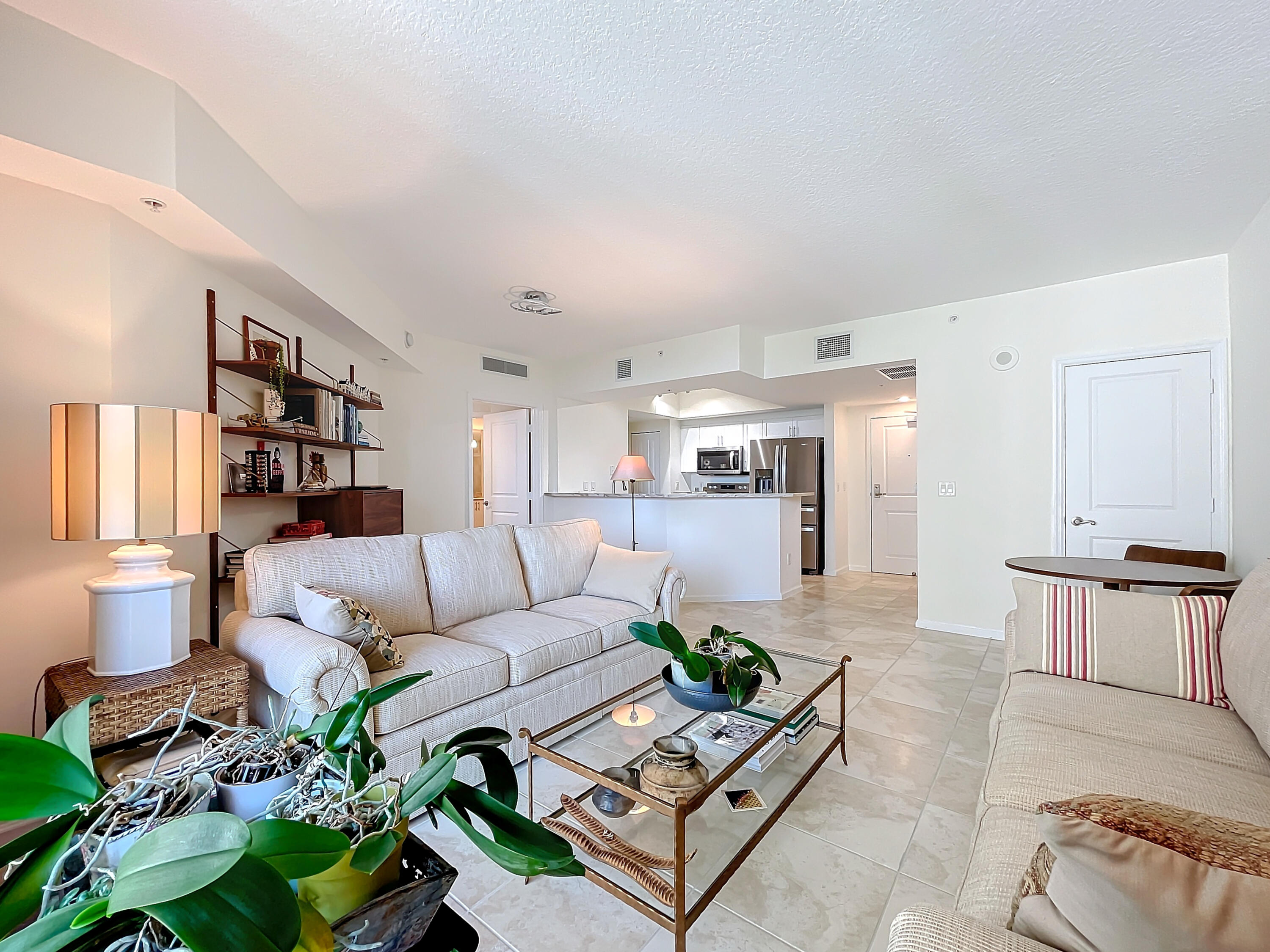 a living room with furniture hard wood floor and a lamp