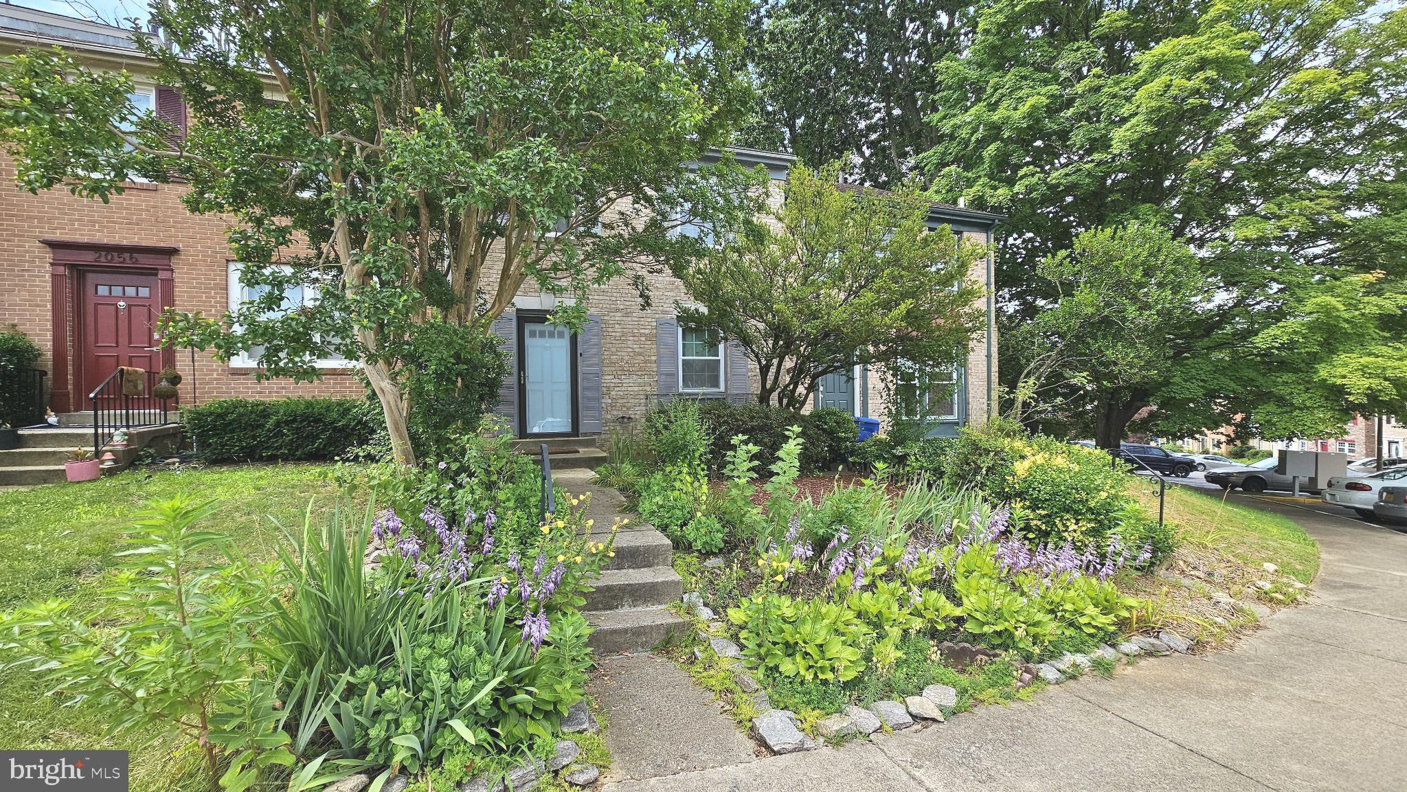 a front view of a house with a yard and fountain