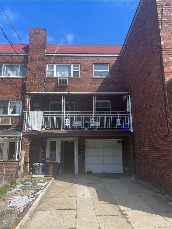 Back of property with a balcony and a garage