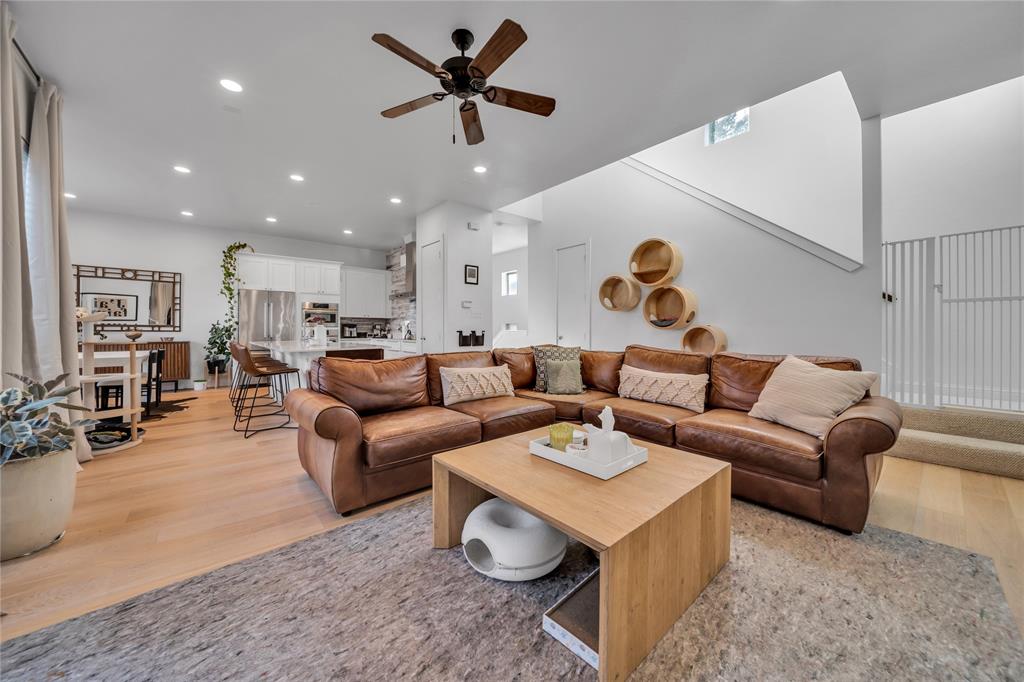 a living room with furniture kitchen view and a chandelier