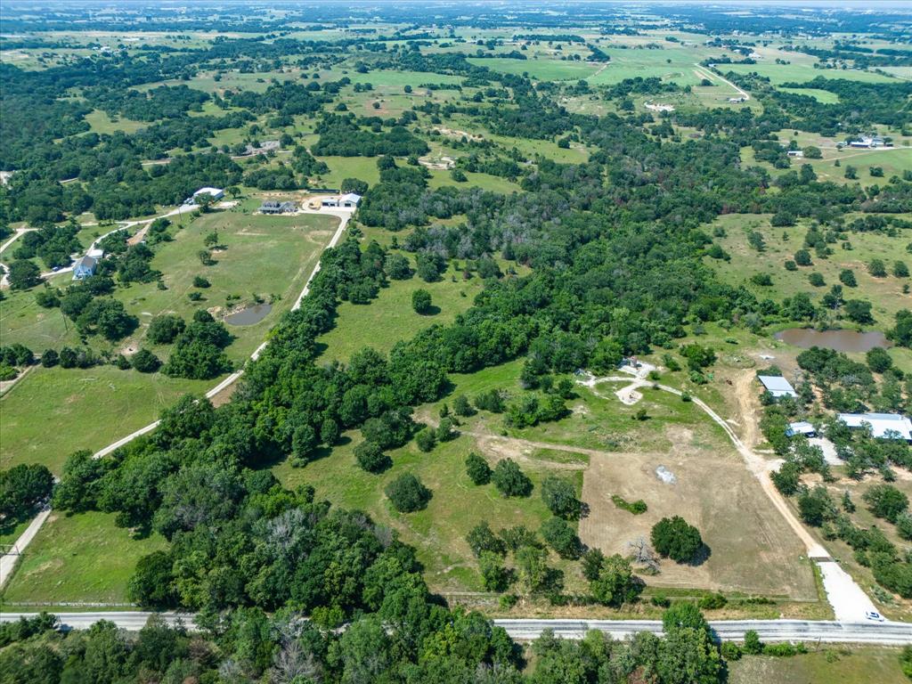 an aerial view of residential houses with outdoor space and trees