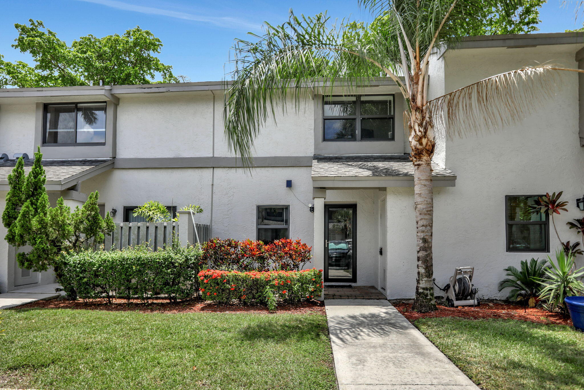 a front view of a house with a yard and potted plants