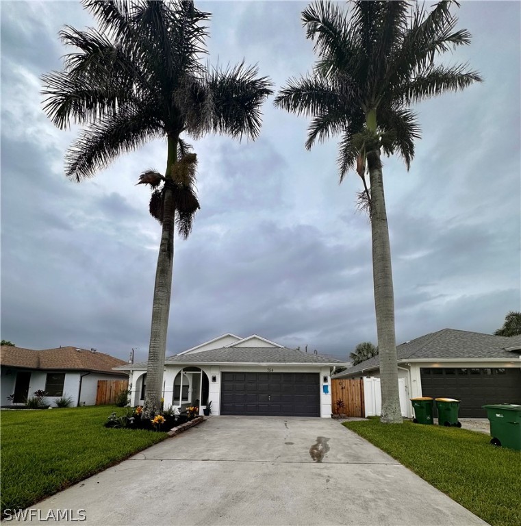 a front view of a house with a yard and palm tree