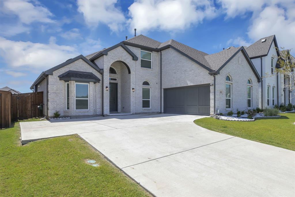 a front view of a house with yard and garage