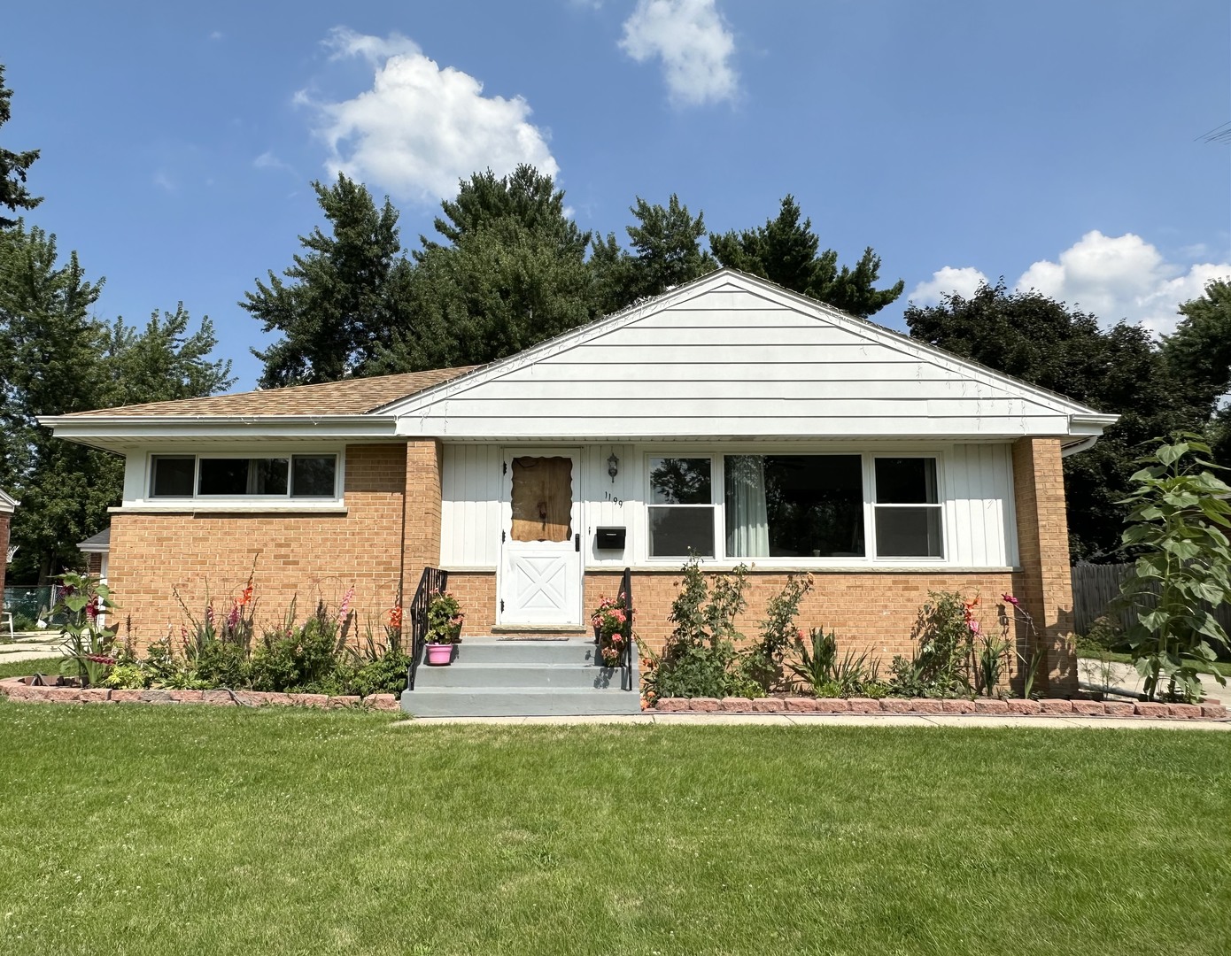 a front view of a house with a garden and yard