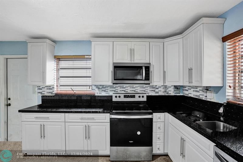 a kitchen with a stove and a white cabinets