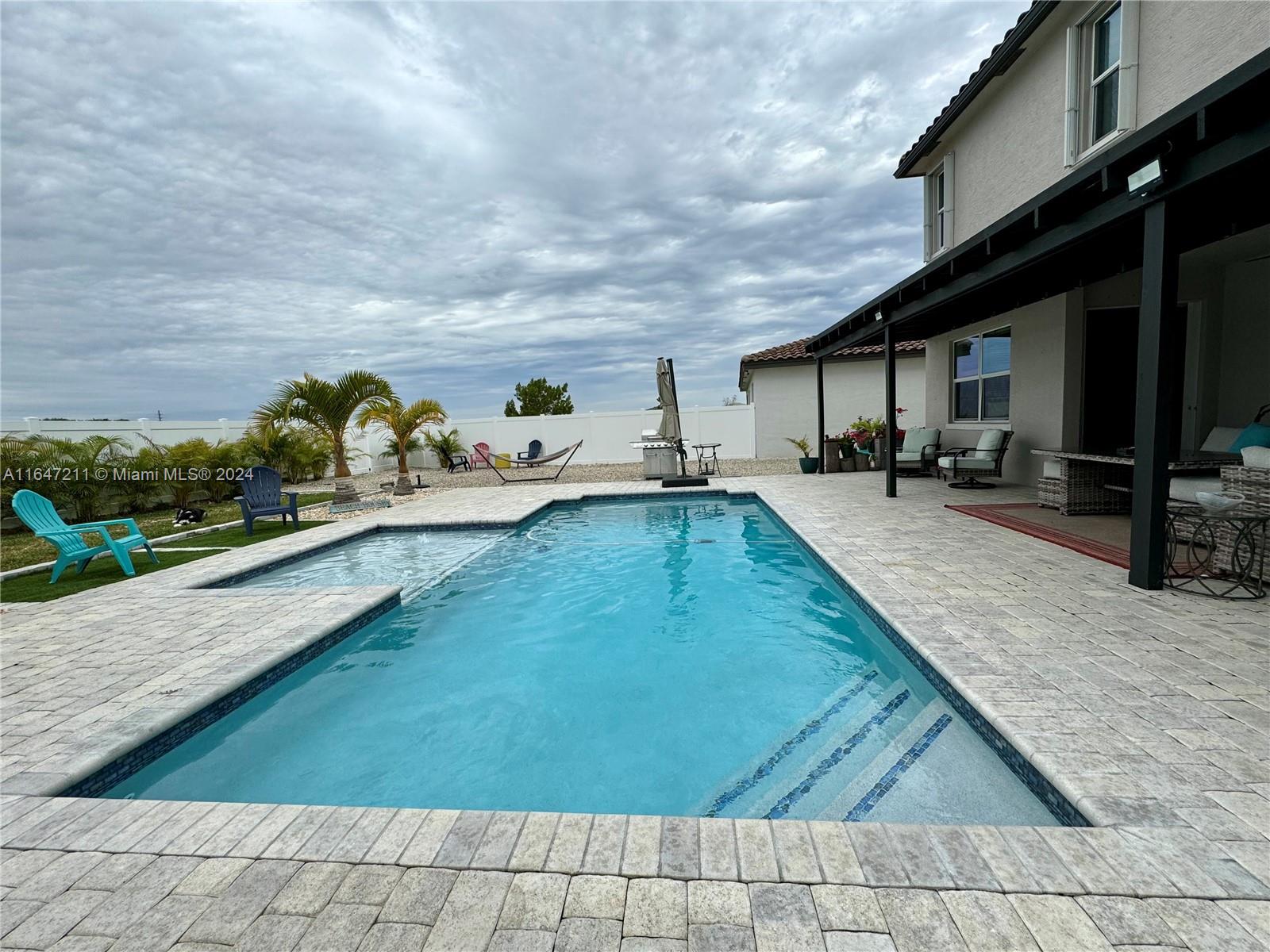 a swimming pool view with a outdoor seating space