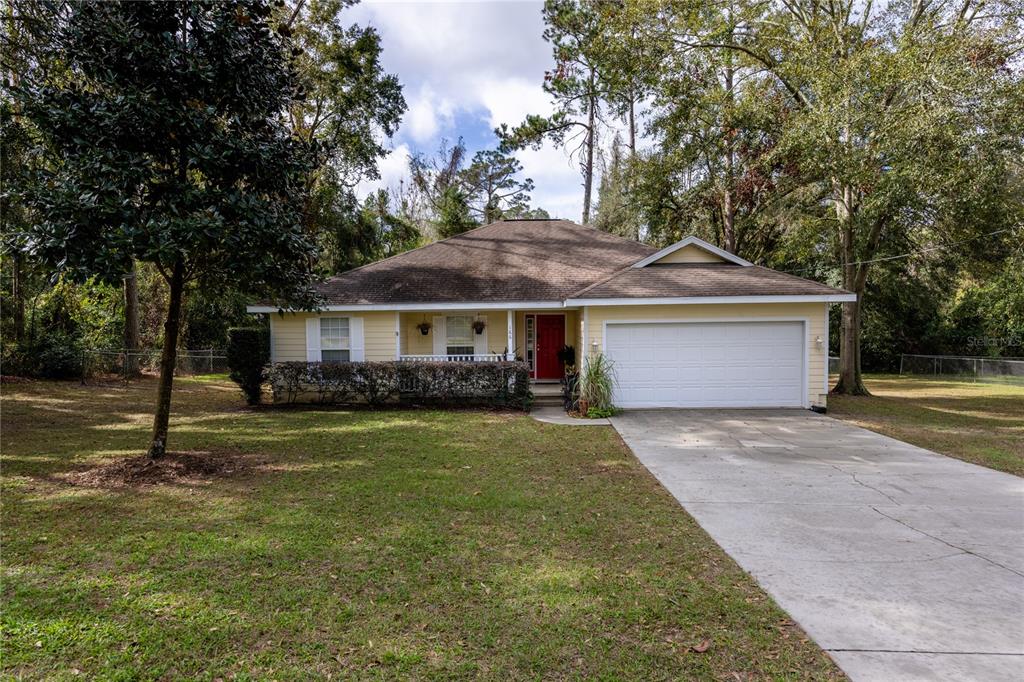 a front view of a house with a garden and trees