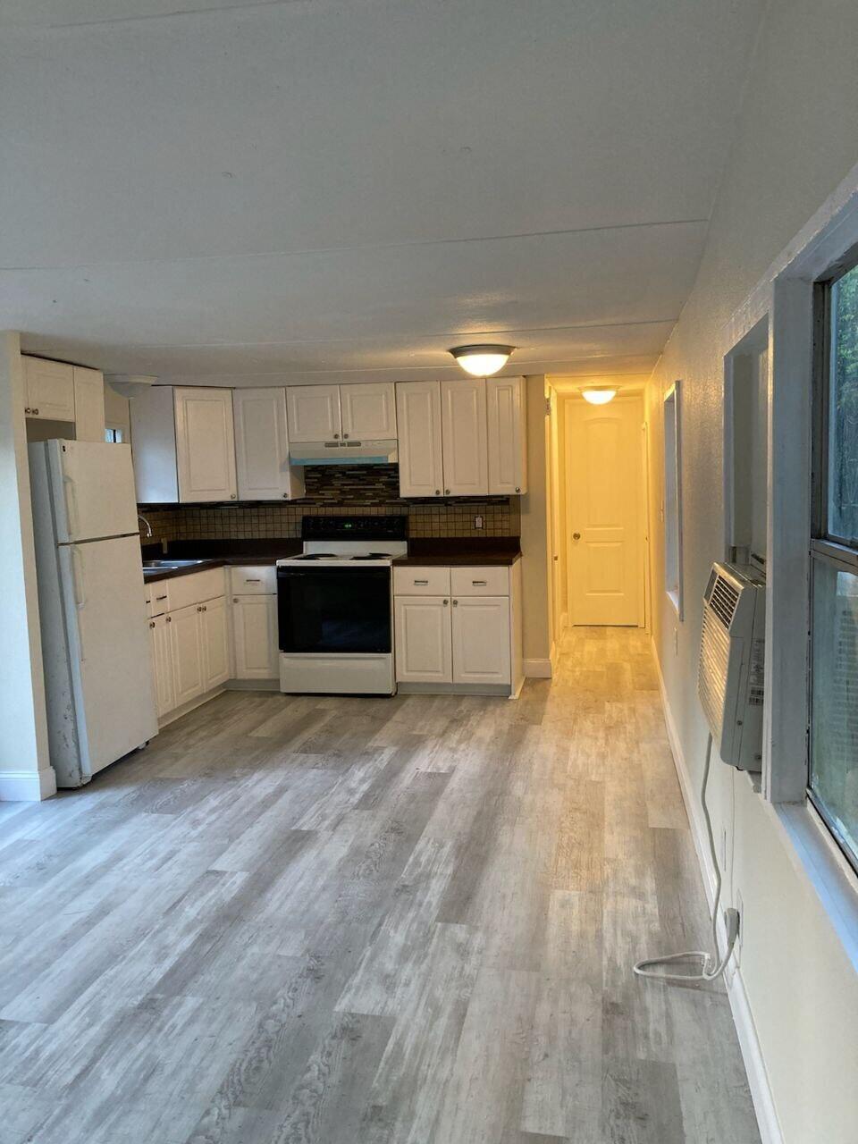 a kitchen with granite countertop a refrigerator and a sink