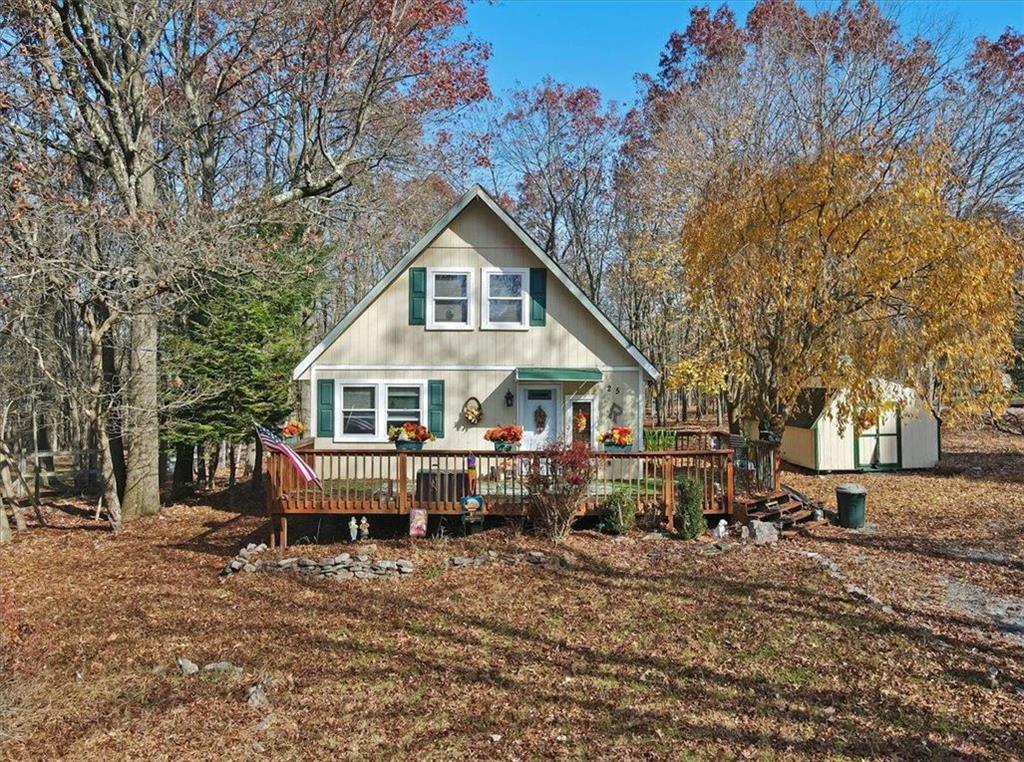 a view of house with a yard and trees