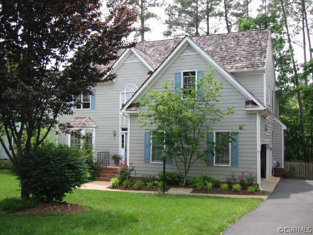 a front view of a house with a garden and plants