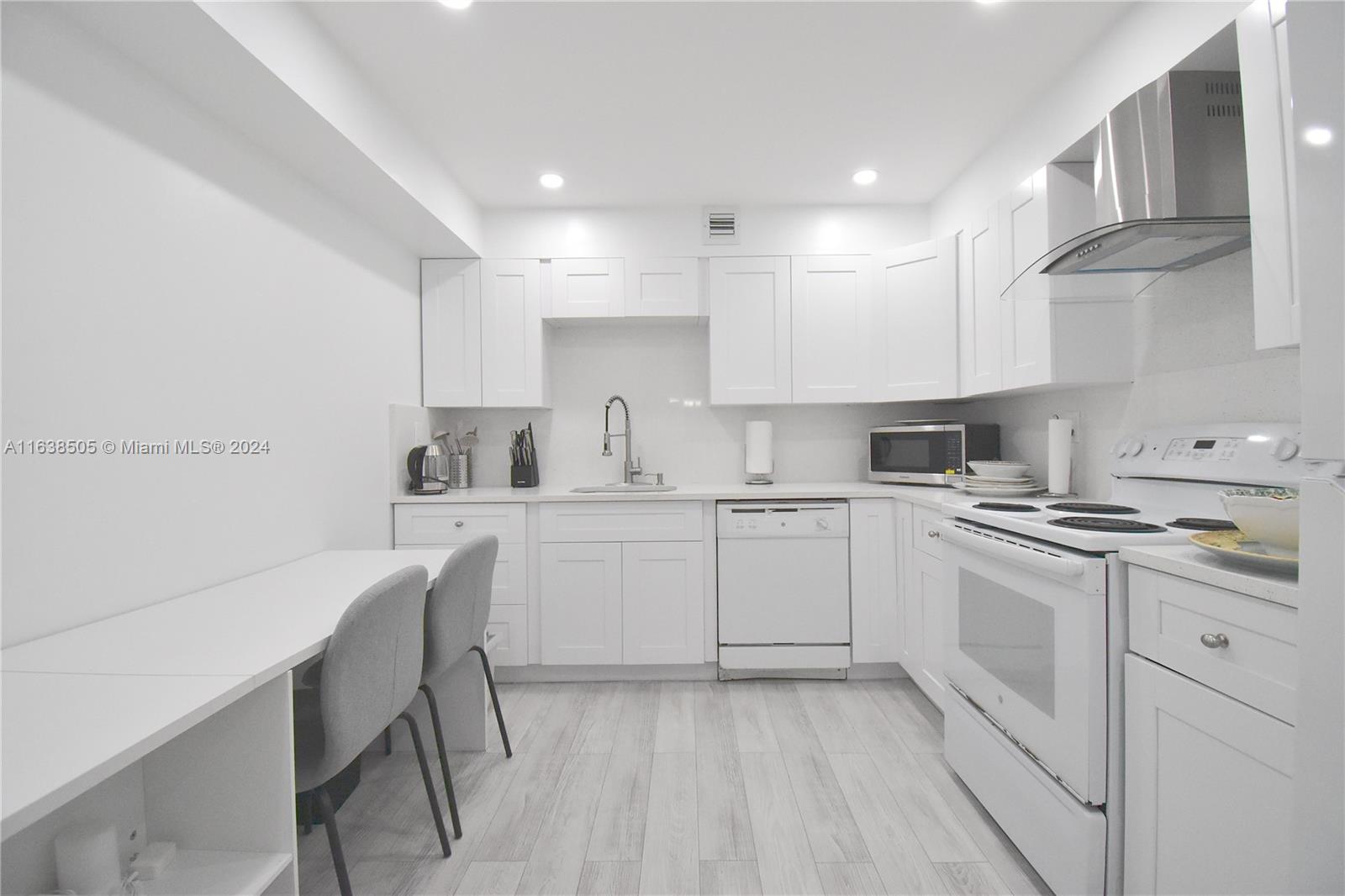 a kitchen with cabinets appliances a sink and a counter top space