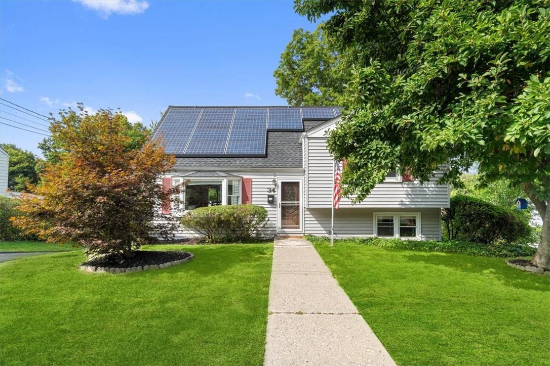 View of front of house with a front lawn and solar panels