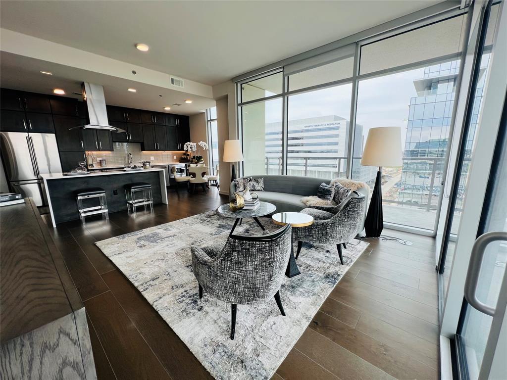 a living room with dining room and kitchen view with wooden floor