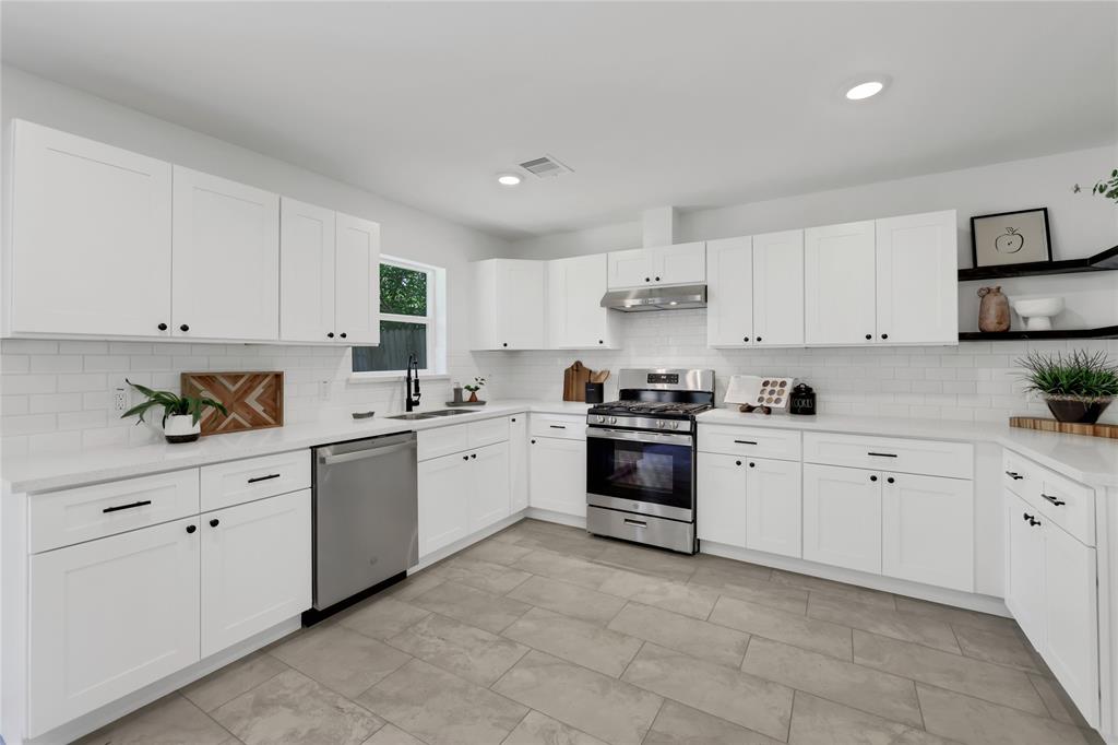 a kitchen with cabinets appliances a sink and a counter top