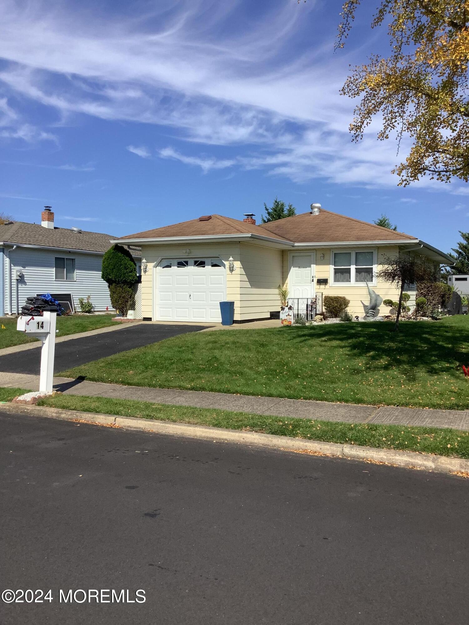 a view of a house with a big yard and large trees