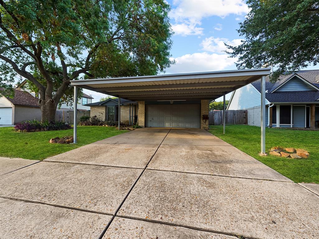 a backyard of a house with large trees and plants