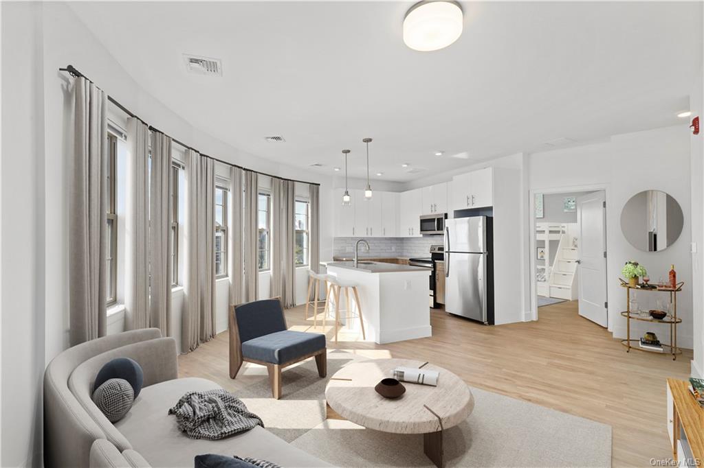 a living room with furniture and kitchen view