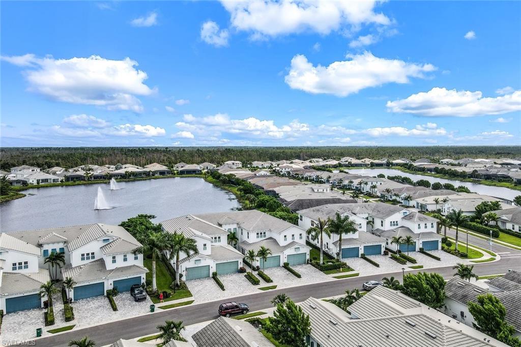 an aerial view of a city with lots of residential buildings ocean and mountain view in back