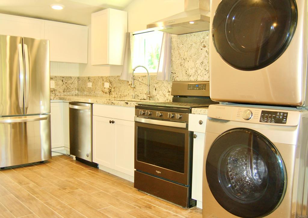 a view of a kitchen with a stove a washer and dryer