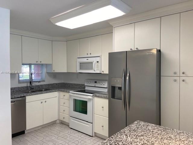 a kitchen with a white cabinets and white appliances