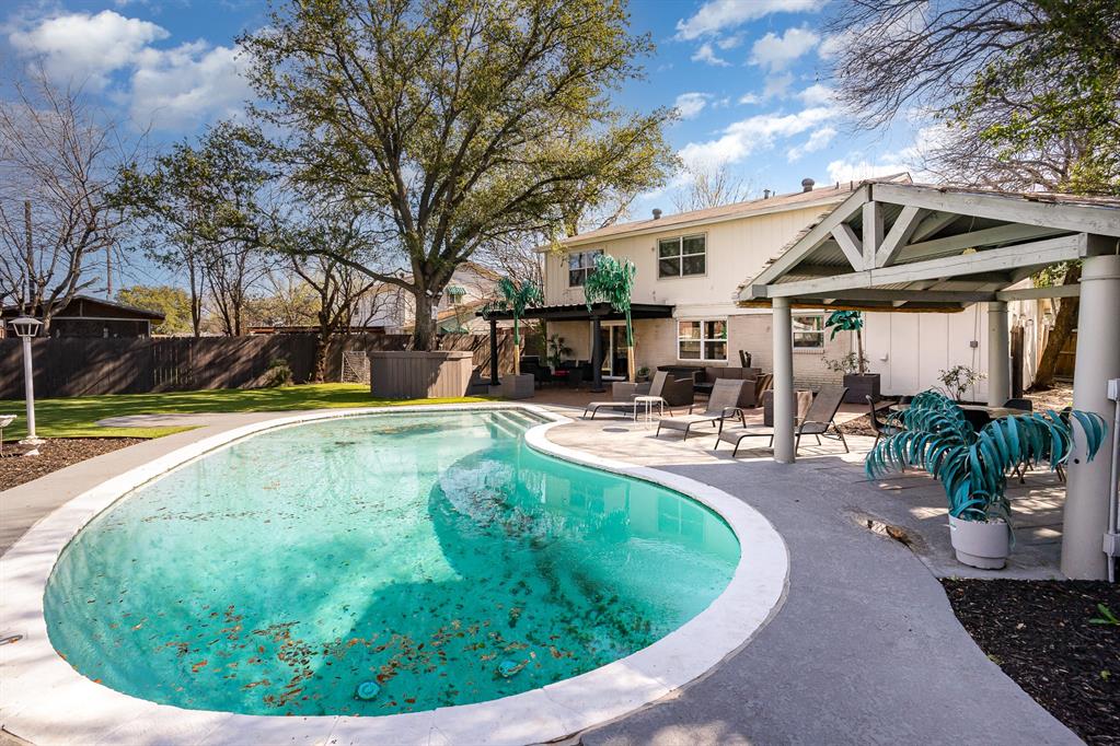 a swimming pool with outdoor seating and yard