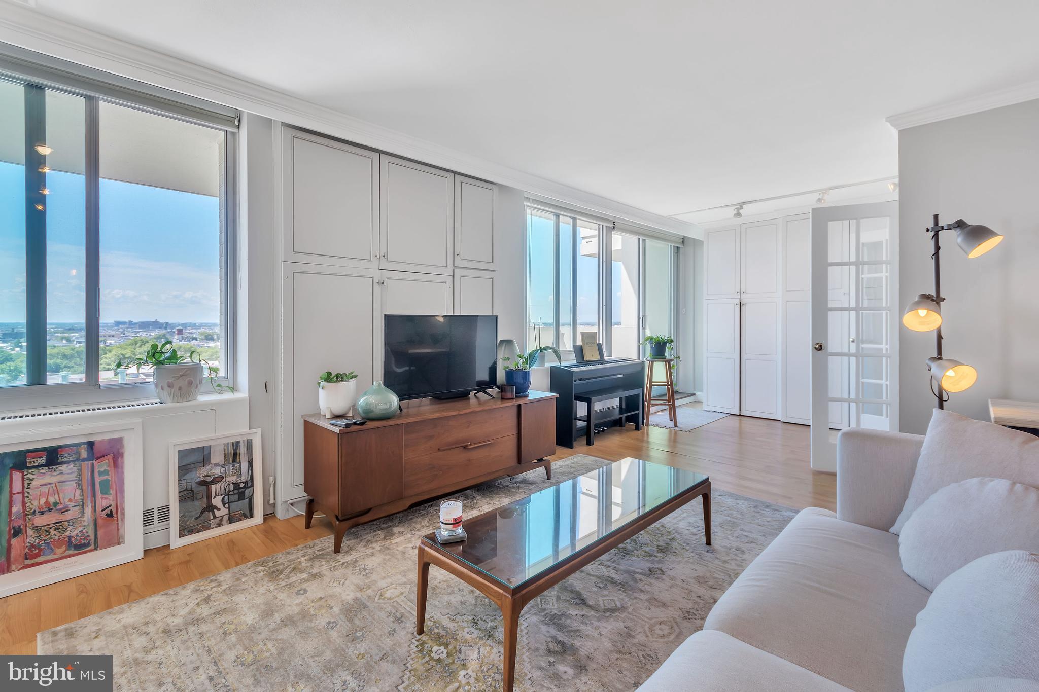 a living room with furniture a flat screen tv and a large window