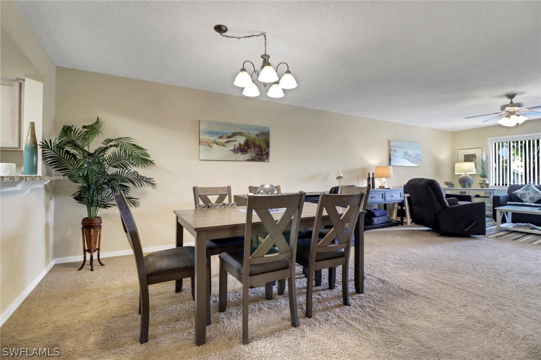 a living room with furniture a chandelier and a dining table