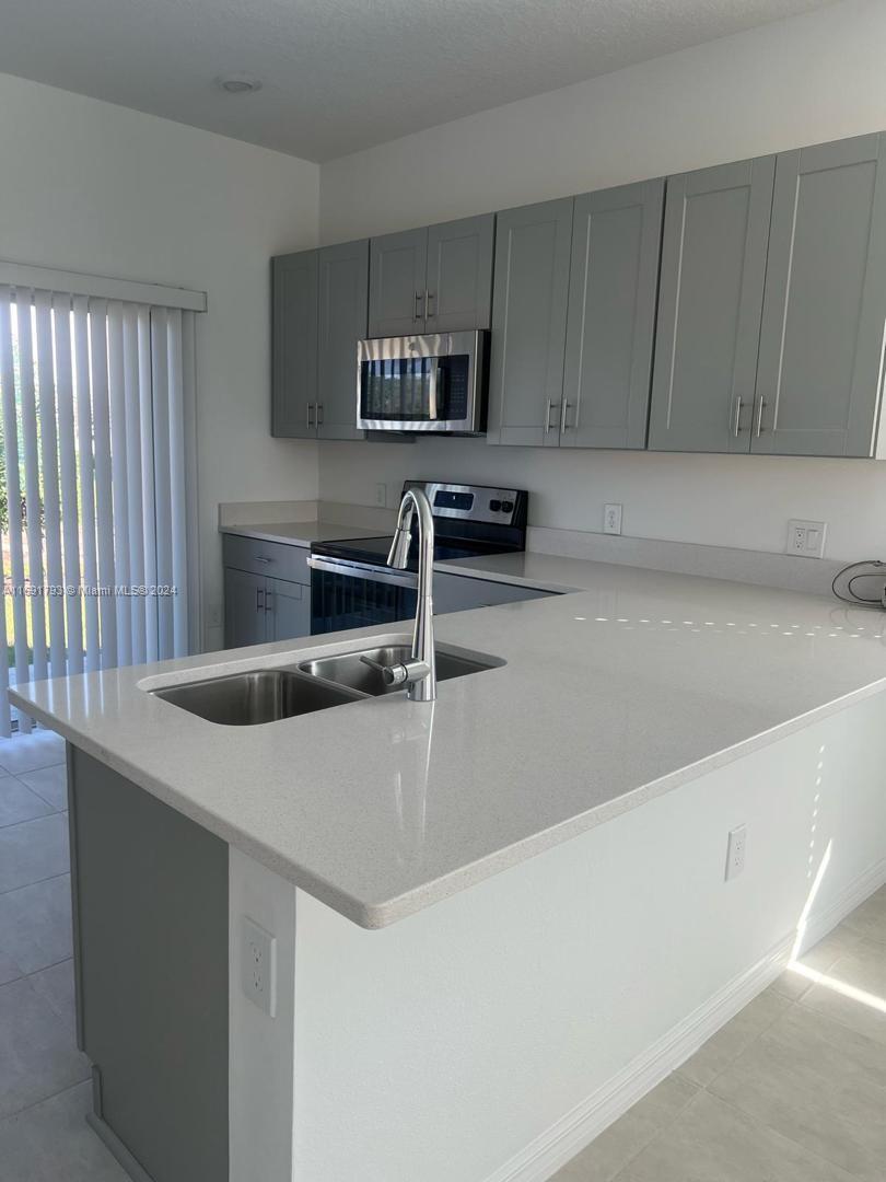 a kitchen with stainless steel appliances a sink and a microwave